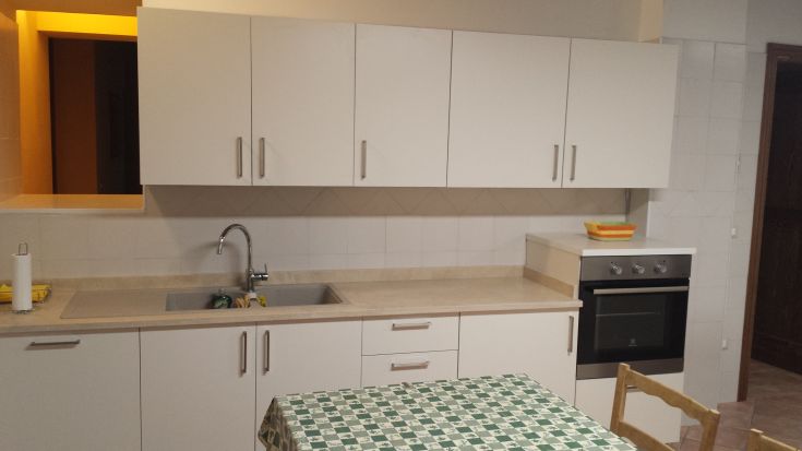 Modern kitchen with stove, sink, and dining table, designed for practicality and functionality.