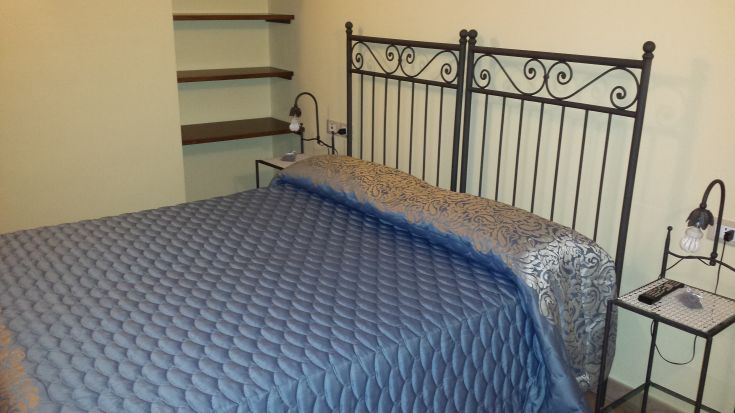 Cozy bedroom featuring a double bed with blue-toned furnishings.