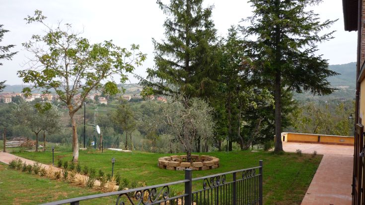 A well-kept garden with trees and plants, located in a hilly area. Perfect for moments of tranquility.