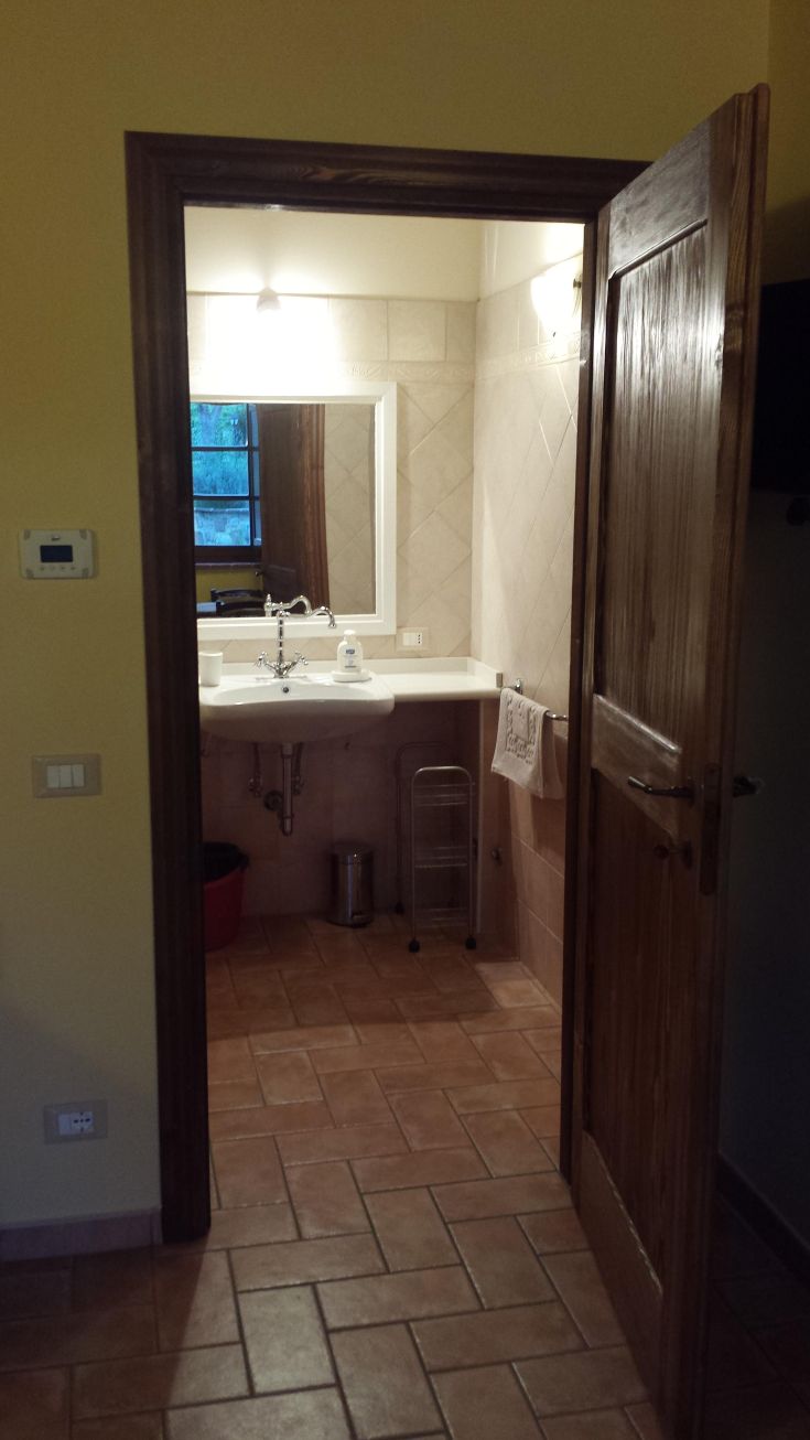 A well-furnished bathroom with ceramic tiles and a modern sink, illuminated by warm light.