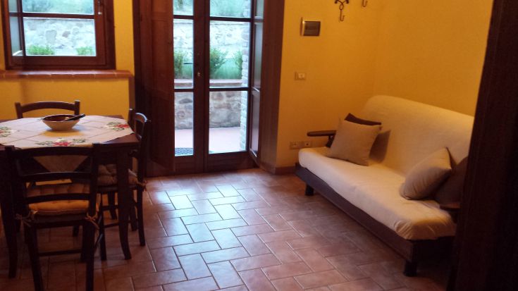 Bright and simple living room furnished with a sofa and dining table, perfect for sharing moments.