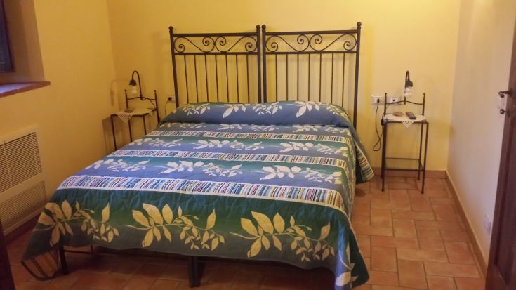 Cozy room with a double bed and minimalist decor, perfect for a relaxing stay.