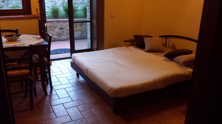 Cozy apartment with a double bed and dining area, filled with natural light.