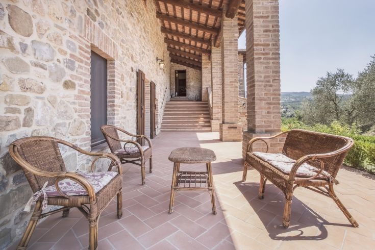 A simple porch with rattan chairs, ideal for relaxing moments outdoors.
