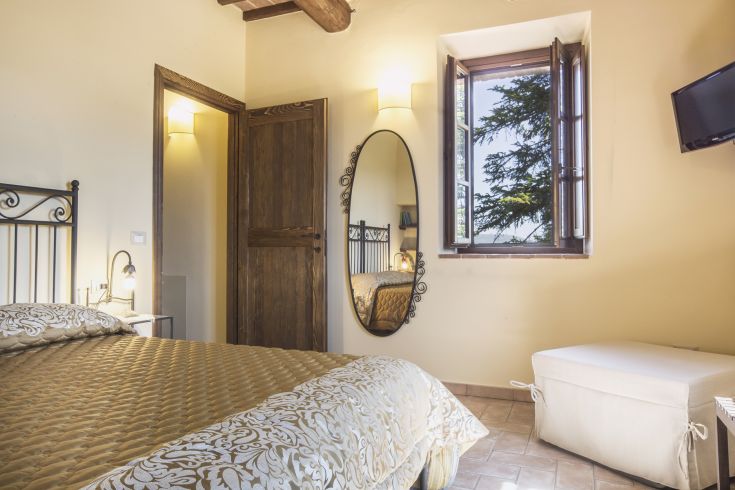 Cozy room with simple elements, featuring windows overlooking the surrounding greenery.