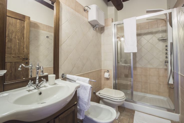 An elegantly designed bathroom with a shower and sink, featuring warm tones and natural materials.