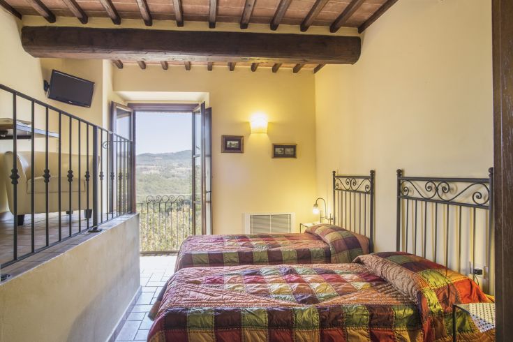 Simple room with single beds and a view of the surrounding hills.