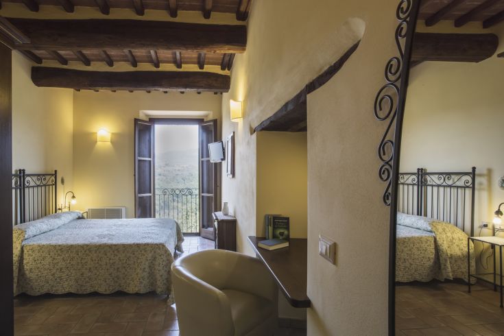 Simple room with two beds, overlooking a natural scene, perfect for moments of tranquility.