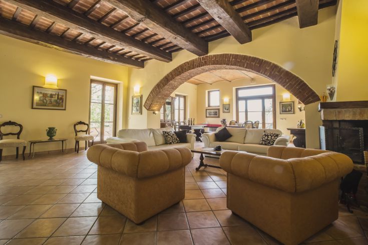 A well-lit living area with comfortable sofas and a large architectural arch. Cozy and relaxing atmosphere.