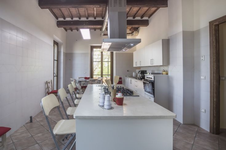 Modern and bright kitchen in a renovated palace, overlooking a large garden.