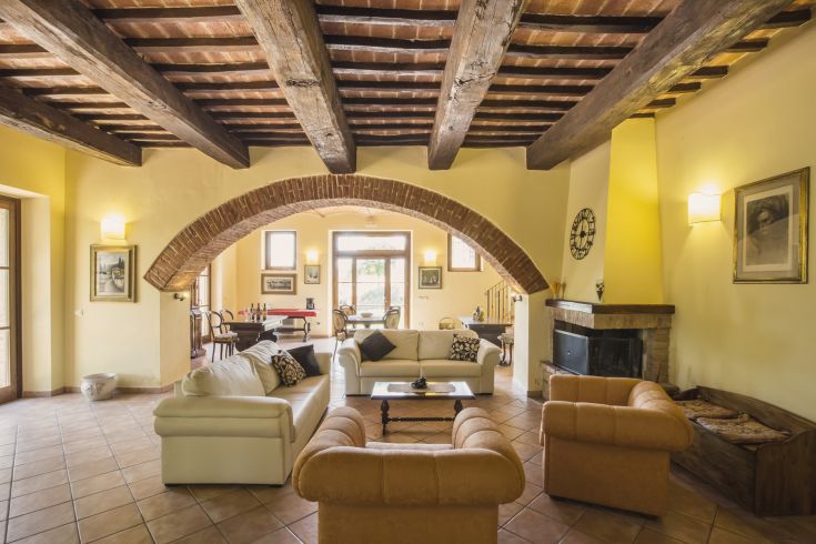 Spacious living room with wooden ceilings and simple design furniture, perfect for relaxation.