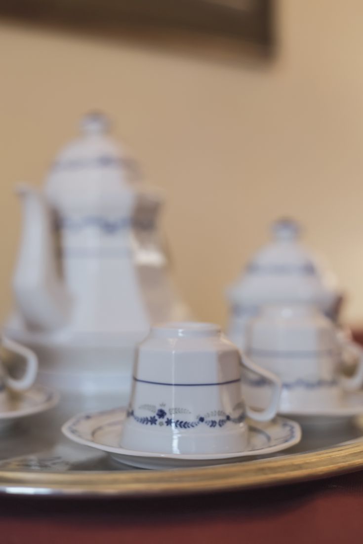 Simple tea set with white ceramic cups and teapot, featuring subtle decoration.