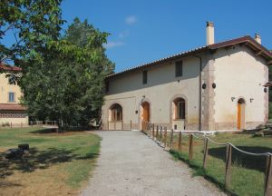 A farmhouse surrounded by greenery at Oasi La Valle, perfect for a peaceful and relaxing stay.