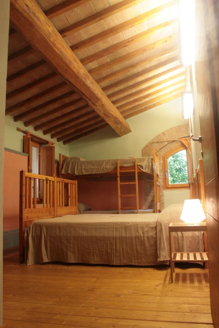 Cozy room with bunk beds and a double bed, wooden furnishings, and natural light.