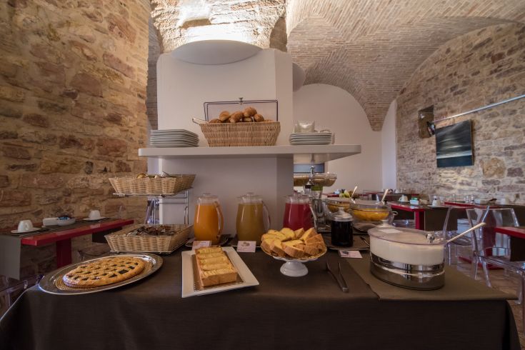 Colazione con una selezione di dolci e succhi in un ambiente semplice e accogliente.