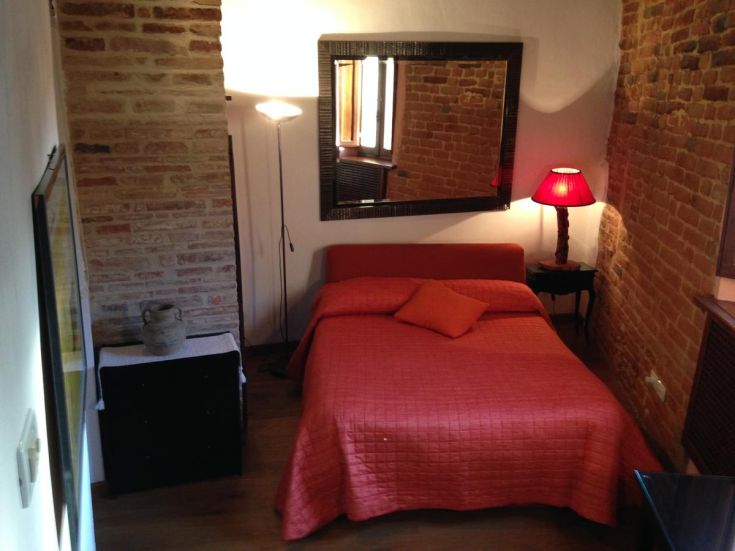 Cozy room with a double bed, decorated in warm tones and wood, creating a comfortable atmosphere.