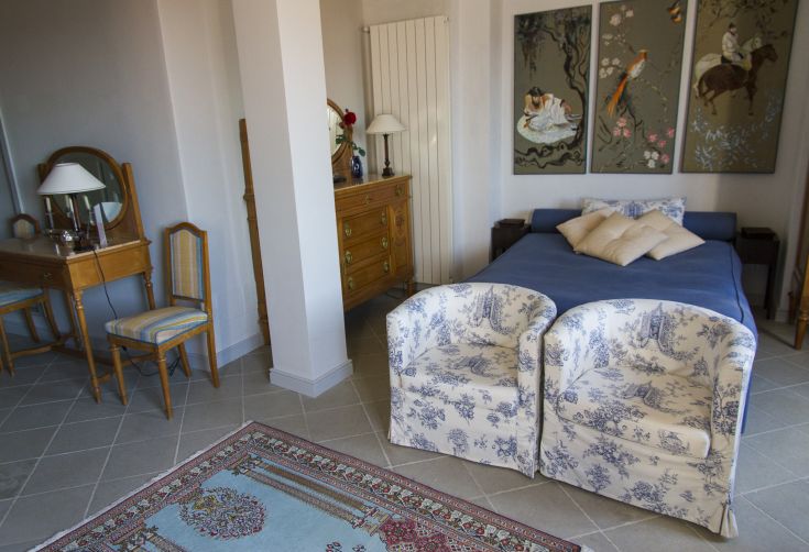 Comfortable room in a historic building, featuring a double bed and sofas, located in a culturally rich area.