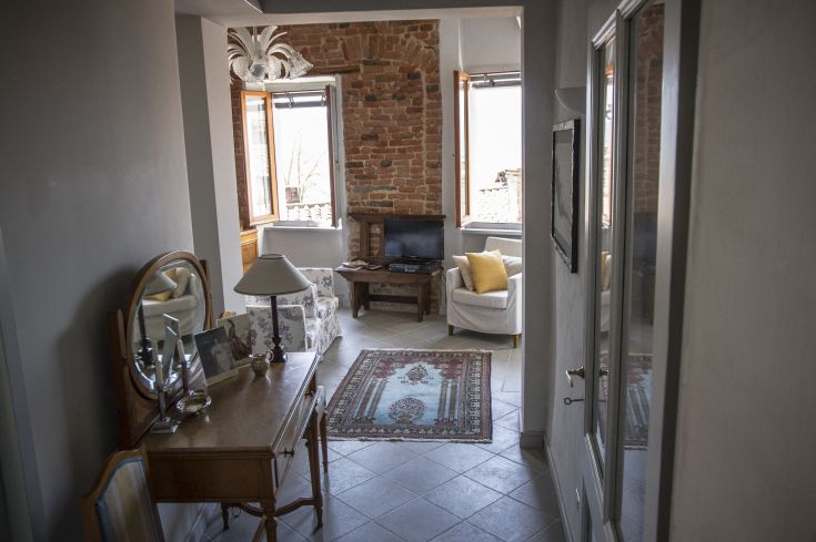 Cozy living room with brick walls, tastefully furnished and bright, perfect for relaxing moments.