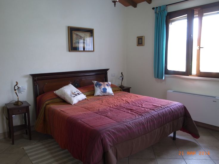 A simple, bright bedroom with warm tones and comfortable furnishings.