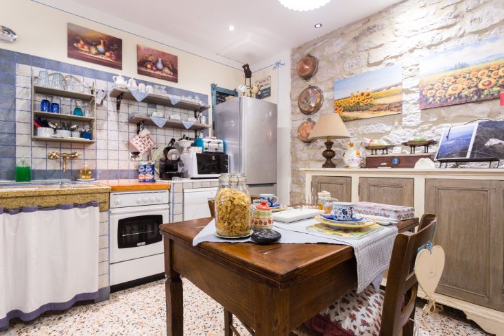 Cucina semplice e confortevole con elementi in pietra e decorazioni floreali.