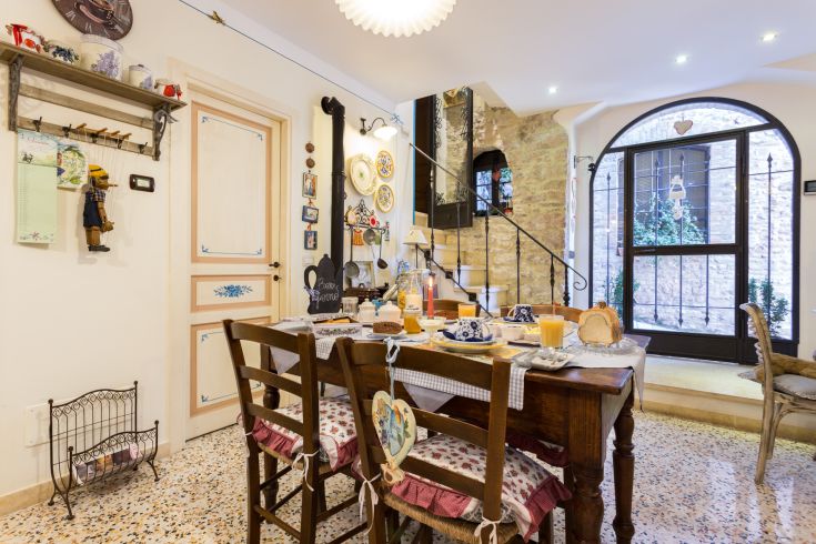 Una cucina semplice e accogliente, con un tavolo apparecchiato e decorazioni sobrie.