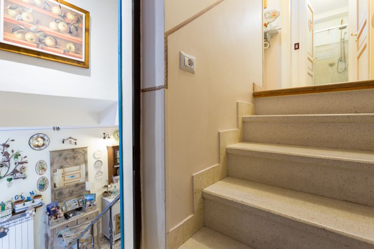 Scena delle scale che portano al piano superiore, con decorazioni interne semplici e accoglienti.