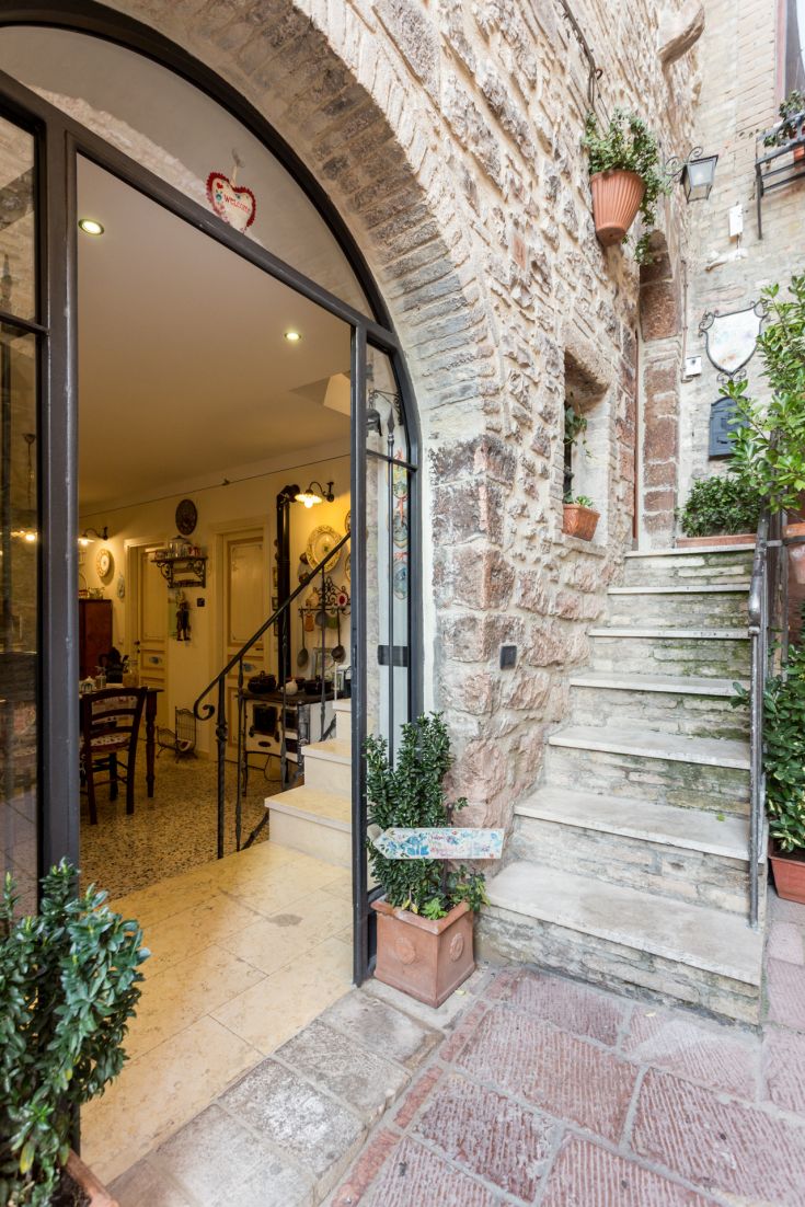 Entrando in un angolo storico, con scale in pietra e piante decorative che creano un ambiente grazioso.