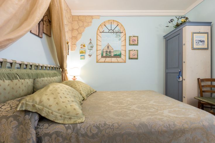 Camera confortevole, arredata con tonalità soft e semplici decorazioni.