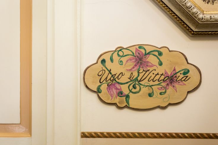 Insegna decorativa con nomi e fiori, che trasmette un senso di accoglienza.