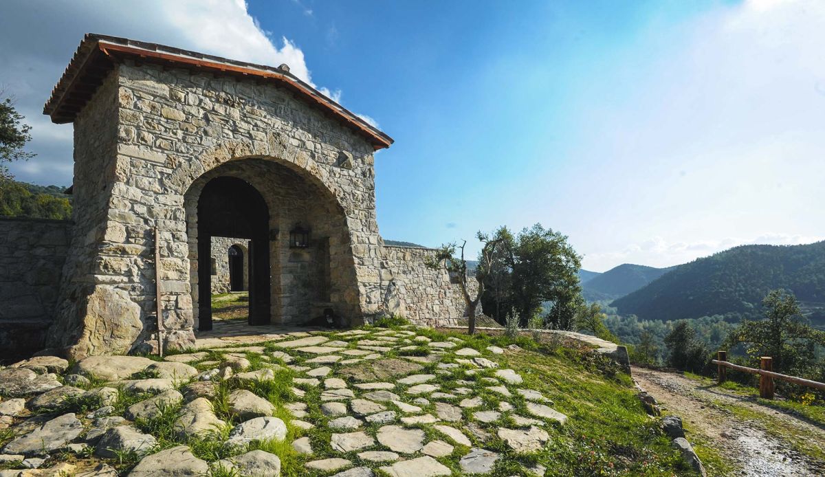 A simple stone entrance leading to the surrounding natural area.