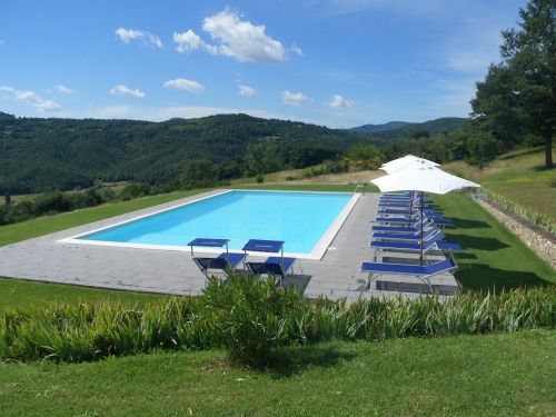 Ein Pool, umgeben von einem grünen Garten, gelegen in der Ruhe der umbrischen Landschaft.