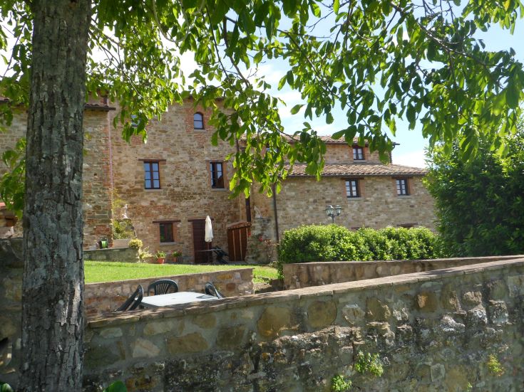 Un bâtiment ombrien entouré d'arbres et de nature, idéal pour des vacances relaxantes.