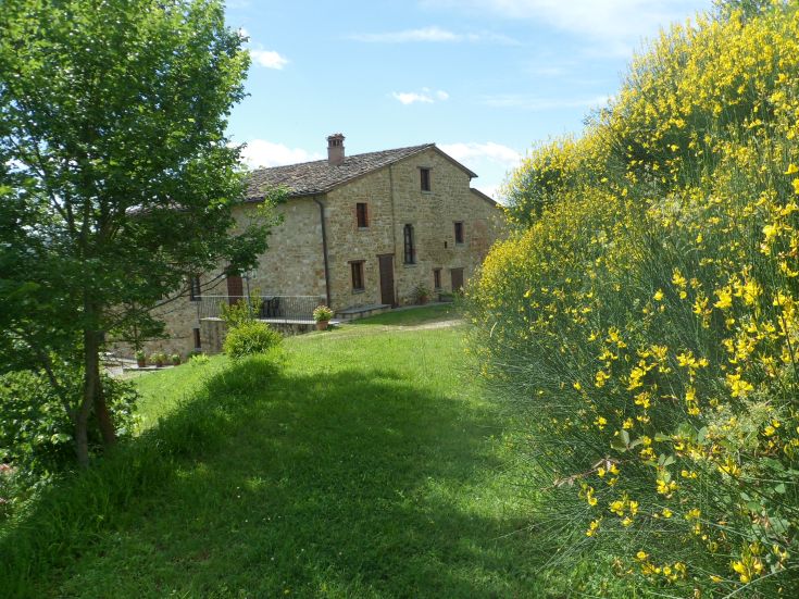 Un bâtiment historique ombrien entouré de verdure, idéal pour des moments de détente dans la nature.