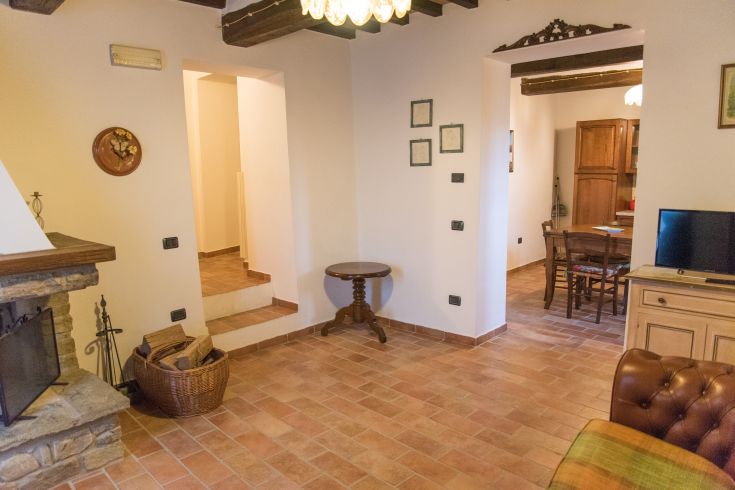Intérieur d'un palais ombrien, avec des meubles rustiques et une ambiance chaleureuse.