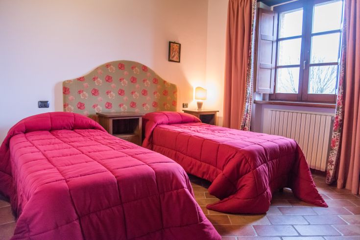 Chambre avec lits simples et vue sur le paysage ombrien, idéale pour un séjour paisible.
