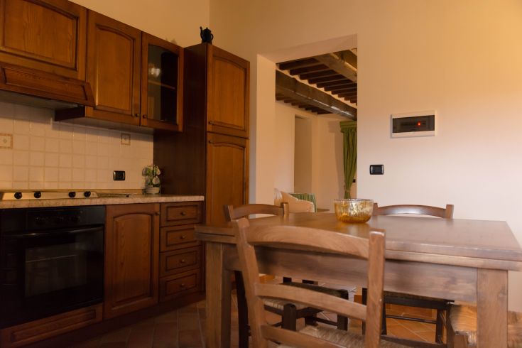 Cuisine en bois avec une table à manger, créant une atmosphère chaleureuse et accueillante.