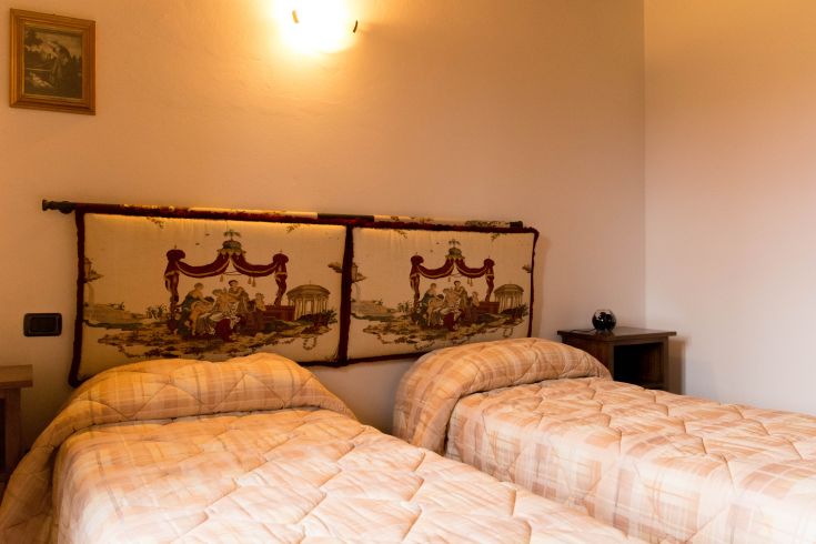 Chambre avec deux lits, décorée avec des tissus simples, offrant une atmosphère relaxante.