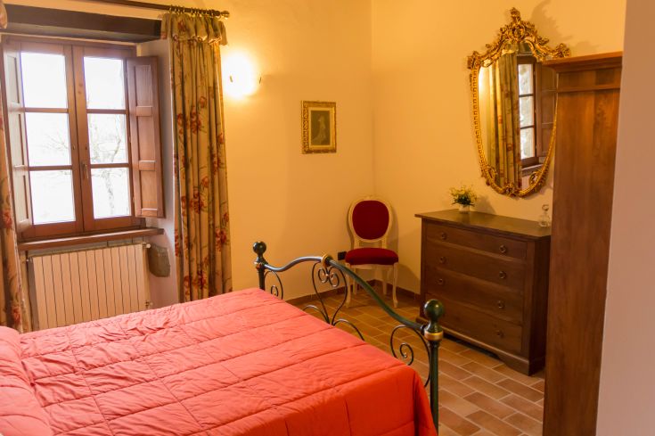 Chambre confortable dans un agriturismo ombrien, avec un mobilier simple et un style accueillant.