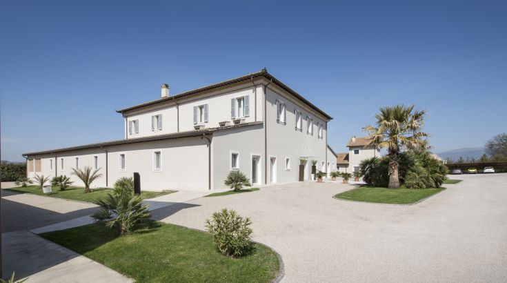 Eine moderne Struktur umgeben von einem weitläufigen Garten, bereichert mit Palmen.