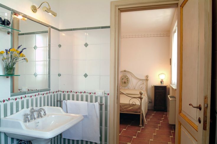 Elegantes Badezimmer angrenzend an ein gemütliches Schlafzimmer, das eine ruhige Atmosphäre schafft.