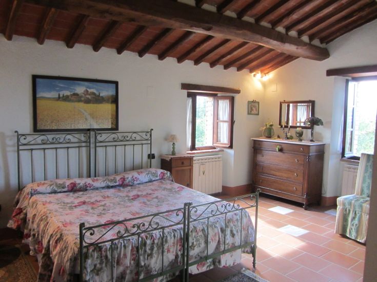 Camera da letto con elementi in legno e decorazioni floreali, adatta per momenti di relax.