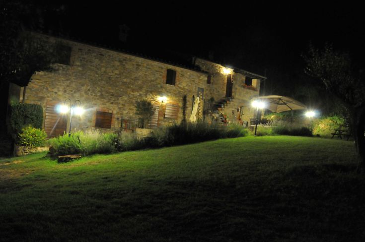 Struttura in pietra ben illuminata, circondata da vegetazione. Un luogo tranquillo situato nel cuore dell'Umbria.