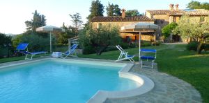 Struttura in pietra con piscina, circondata da ulivi, situata in un contesto naturale tranquillo, perfetta per momenti di relax.