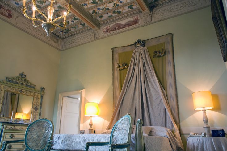 Une pièce avec un plafond décoré et un mobilier simple.