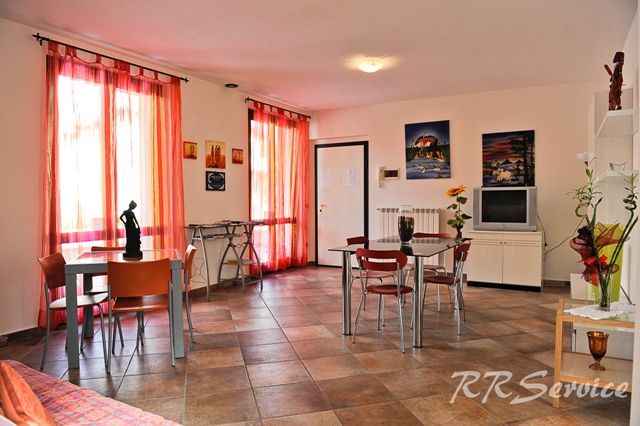 Intérieur d'un appartement contemporain bien meublé, avec de grandes fenêtres et des détails modernes.