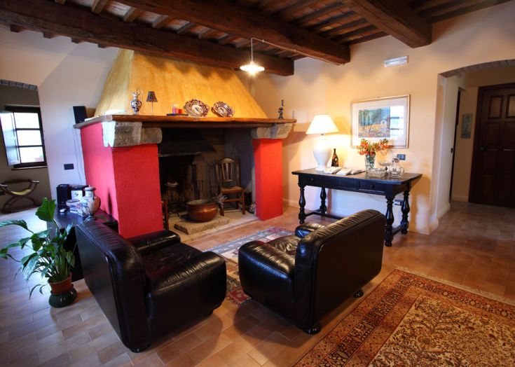 Ein gemütliches Wohnzimmer mit Kamin, Ledersesseln und warmen Tönen, ideal zum Entspannen.