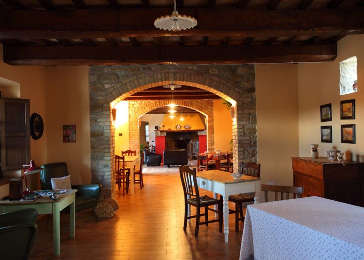 Das Innere eines rustikalen Agriturismos in der Natur, einfach und gemütlich eingerichtet, mit warmem Licht.