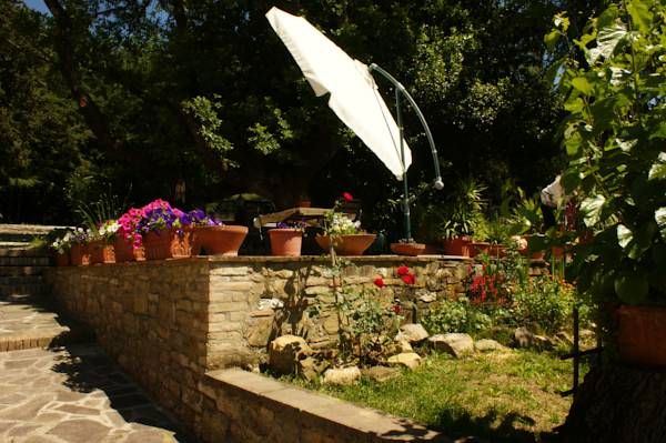 Un farmhouse rénové situé dans un jardin bien entretenu et verdoyant, offrant une atmosphère tranquille.