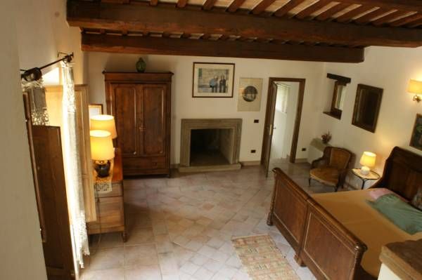 Stanza accogliente in un edificio umbro ristrutturato, arredata con mobili tradizionali e immersa nella natura.