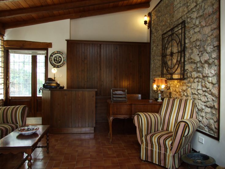 Interno di un edificio luminoso, con finiture in legno e pietra, ben organizzato e accogliente.